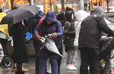 New Yorklular hafif kar ve yağmurla karşılaştı. 20 Aralık 2024, New York, ABD: New Yorklular ve turistler Cuma günü hafif kar ve yağmurla karşı karşıya kalırlar (niyi fote / theenews2)
