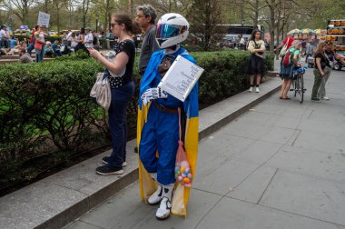 Protestocular koz yönetimini kınamak için ülke çapında şehirlerde toplandılar. 19 Nisan 2025, New York, New York, ABD: Ukrayna bayrağıyla örtülmüş ve Rusya 'ya karşı bir protesto gösterisi düzenleyen bir kişi 