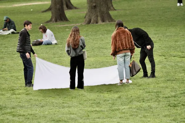 18 Nisan 2025, New York, ABD: New Yorklular New York 'taki Central Park' ın büyük çimlerinde güzel bir cuma gününü kutlarken, spor yaparken, piknik yaparken (niyi fote / the enews2)