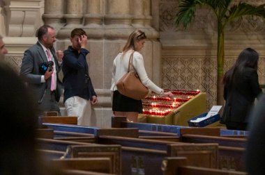 New York Başpiskoposu Kardinal Timothy Dolan Papa Francis için bir ayin düzenliyor. 22 Nisan 2025, New York, New York, ABD: Papa Francis için St. Patrick Katedrali 'nde özel bir ayin sırasında bir kişi mum yaktı.)