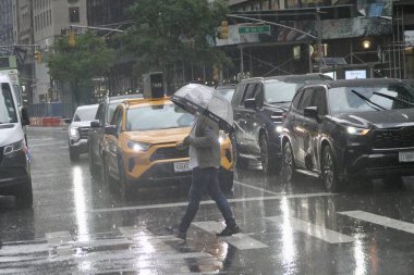 New York, ABD: 16 Mayıs 2025 - New Yorklular daha erken sağanak yağış sırasında sokaktalar. (Niyi Fote/Thenews2)