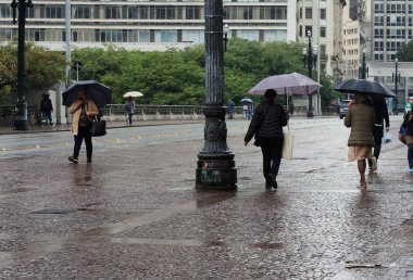 Brezilya, Sao Paulo: 3 Haziran 2025 - Yayalar Sao Paulo şehir merkezinde soğuk ve yağmurla karşı karşıya. Ulusal Meteoroloji Enstitüsü (INMET) Sao Paulo eyaletini 
