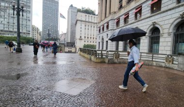 Brezilya, Sao Paulo: 3 Haziran 2025 - Yayalar Sao Paulo şehir merkezinde soğuk ve yağmurla karşı karşıya. Ulusal Meteoroloji Enstitüsü (INMET) Sao Paulo eyaletini 