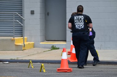 New York Polis Departmanı olay yeri inceleme ekipleri olay yerinde bulunan kovanları işaretleyen kanıt işaretleri ve bir telefon yerleştirdiler. Ayrıca çifte cinayet mahallinde park etmiş bir aracın yanına da bir delil işareti yerleştirildi. (Kyle Mazza / the Newws2)