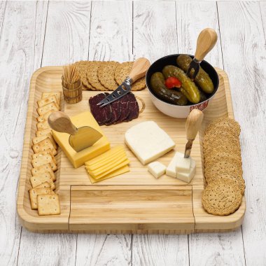 Atıştırmalıklı peynir tahtası: ahşap arka planda meyveli, şekerli ve etli farklı çeşitte sert ve yumuşak peynir.