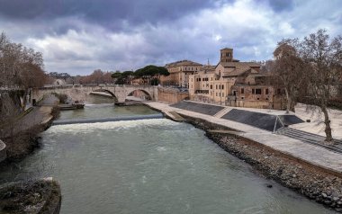 A picturesque view of the Tiber River and a historic bridge in the charming Trastevere neighborhood of Rome, Italy. This popular tourist destination offers a blend of history, culture, and vibrant nightlife clipart