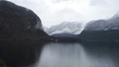 Ünlü kilise kulesi Hallstatt şehrinin manzarası, üzerinde bulutlar yüzen Hallstatt Gölü ve bulutlu bir günde çevreleyen dağlar. Avusturya Alpleri 'nde popüler bir turizm beldesi. 4K video