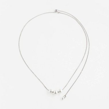 Beyaz arka planda izole edilmiş barok inci kolyeli zarif gümüş bir zincir. Üst görünüm