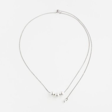 Beyaz arka planda izole edilmiş barok inci kolyeli zarif gümüş bir zincir. Üst görünüm