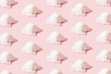 Pembe arka planda beyaz pamuk bulutları. Pastel desen.