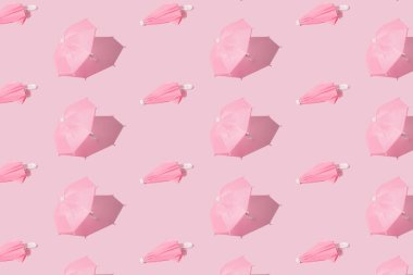 Açık ve kapalı pembe ubrella pembe pastel arka plan. Desen.