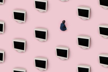 Küçük bir çocuk oturuyor ve büyük bir karaciğer monitörüne bakıyor. Pembe arka plan. Desen.