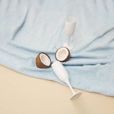 Havlusunda hindistan cevizi olan beyaz bir bardak şampanya..