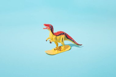 Mavi arka planda dinozor sörfü.