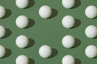 Yeşil pastel arka planda beyaz golf topu. En küçük desen.