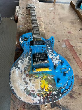 Elektro gitarı, atölyenin iç tarafındaki ahşap çalışma tezgahına kapat. Boyanın bir kısmı tamamen sökülmüş. Tamir günü düz görüş için hazır.