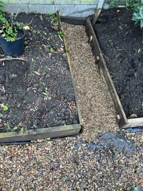 Tahta döşeme ile yükseltilmiş bahçe projesinin peyzajı sınır organik büyüyen alanlara kenar, yol üzerinde çakıllarla kaplı kara zemin örtüsü açık araziyi tamamlamak için.