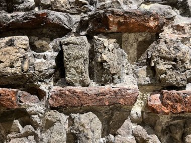 Close up of ancient thin red building bricks with grey mortar design part of ancient historical Roman castle wall in Essex England uk