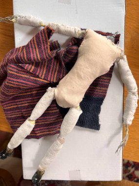 Metal kaplamalı kil eklemli insan figürünün el yapımı armatürü ve kablo, bez, kil ve ahşap yüzey arka planındaki malzeme giysileri ile hareket durması için hareket eden hareketler.