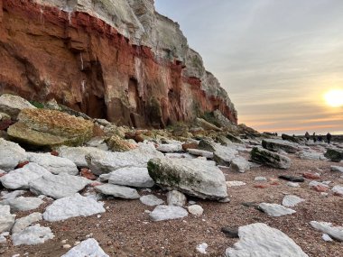 Hunstanton plajındaki tarih öncesi uçurum manzarası milyonlarca yıllık katmanlar halinde beyaz ve pas renginde oluşumlar ve güzel bir bahar gününde kayalara sıkışmış fosiller. 