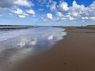 Deniz Palling Norfolk 'un güzel kumlu sahili. Doğu Anglia engin okyanus manzarası. Kum kıyısındaki büyük beyaz mavi gökyüzü.