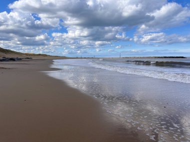 Deniz Palling Norfolk 'un güzel kumlu sahili. Doğu Anglia engin okyanus manzarası. Kum kıyısındaki büyük beyaz mavi gökyüzü.