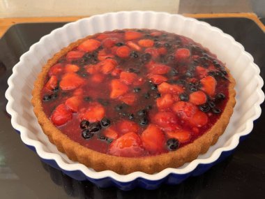 Yeni pişmiş taze ev yapımı sağlıklı meyve turtası ahududu, çilek, organik tahsis edilmiş organik bahçeden siyah ve kırmızı frenk üzümü beyaz flüt çanağı düz yatıyordu.