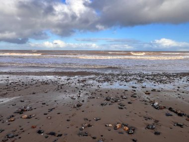 Manzara dramatik kumlu sahil kıyısı okyanus ufkunda bulutlu güzel kış günü sörf dalgaları yüksek rüzgar ve dramatik mavi yuvarlanan bulut kışın Norfolk East Anglia uk