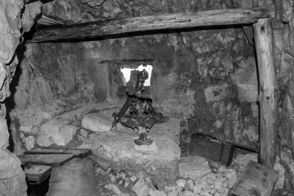 A loophole and an old machine gun in a tunnel of Mount Lagazuoi in the Dolomite Alps, built during the First World, Autonomous Pronvince of South Tirol