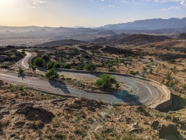 Fas 'ın Anti-Atlas bölgesindeki büyük bir dağ manzarasında bir yol kıvrılıyor.