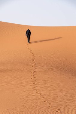 Afrika Sahra, Fas 'taki Erg Chebbi çölünde yürüyen bir adam.