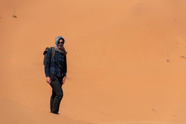 Afrika Sahra, Fas 'taki Erg Chebbi çölünde yürüyen bir adam.
