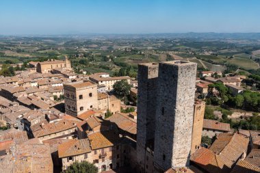 San Gimignano şehir merkezi üzerinde geniş panoramik manzara, Torre Grosso, İtalya 'dan görünen Torri dei Salvucci ortada.