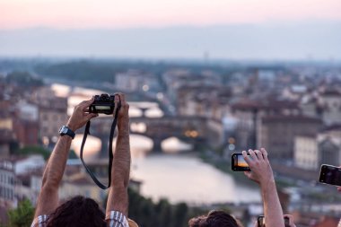 Piazzale Michelangelo 'daki büyük turist kalabalığı Floransa, İtalya' da günbatımının keyfini çıkarıyor