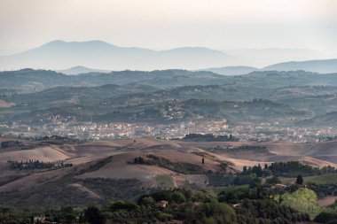 Sabahın erken saatlerinde İtalya 'nın Montaione kenti yakınlarında tepeleri ve selvileri olan tipik Toskana manzarası.