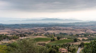 Sabahın erken saatlerinde İtalya 'nın Montaione kenti yakınlarında tepeleri ve selvileri olan tipik Toskana manzarası.