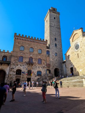 SAN GIMGNANO, ITALY - 20 Eylül 2023 - San Gimignano 'daki ana meydan Piazza del Duomo ünlü saray kuleleri, Palazzo Comunale' in büyük kulesi ve İtalya 'nın merkezindeki katedral