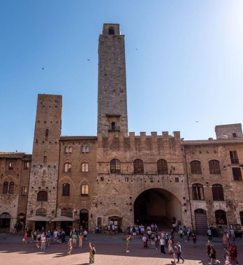 SAN GIMIGNANO, ITALY - 20 SEPTEMBER 2023 - San Gimignano 'daki ana meydan Piazza del Duomo, merkezinde ünlü saray kuleleri, Rognosa kulesi ve Theater dei Leggieri ile, İtalya