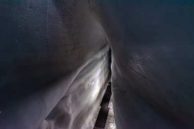 Doğal bir buzul mağarasında dar bir yol.