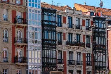 İspanya 'nın Bask ülkesinin özerk bölgesi Bilbao şehir merkezindeki balkon ve koy pencereli konut binalarının tipik ön cephesi