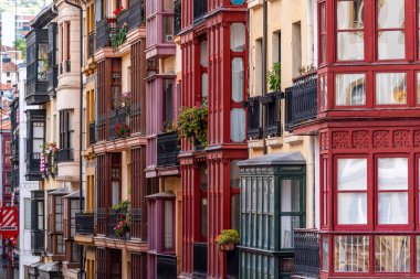 İspanya 'nın Bask ülkesinin özerk bölgesi Bilbao şehir merkezindeki balkon ve koy pencereli konut binalarının tipik ön cephesi