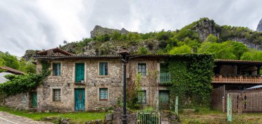 Kuzey İspanya 'nın Asturias kentindeki Picos de Europa dağlarında Cares vadisinin sonundaki Cain de Valdeon köyündeki resimli evler yürüyüş parkurundadır.