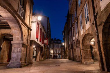 İspanya 'nın Santiago de Compostela şehrinde eski evleri ve manzaralı geçitleri olan boş küçük Rua do Vilar Caddesi.