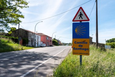 Camino de Santiago sign on a scenic country road, showing pilgrims the way to their destination, Spain clipart