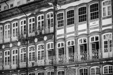 Portekiz 'in Guimaraes şehrinde, Largo do Toural Meydanı' ndaki bir evde birçok penceresi olan geleneksel Portekiz cephesi.