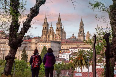 Santiago de Compostela, İspanya - Mai 21, 2024 - İspanya 'daki Alameda Parkı' ndaki ünlü katedral perspektifinden Santiago de Compostela üzerinde günbatımını seyreden hacılar