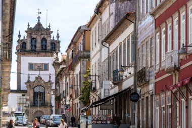 Braga, Portekiz - Mai 24, 2024 - Portekiz 'in Braga kentindeki Dom Goncalo Pereira sokağındaki tipik eski ev cephesi, sokağın sonunda Nossa Sinyora da Torre şapelini gösteriyor.