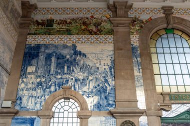 Sao Bento tren istasyonunun duvarındaki Azulejo seramik seramik kiremitler Portekiz 'de Porto halkının yaşamını gösteriyor.