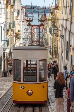 Lisboa, Portekiz - Haziran 04, 2024 - Lizbon, Portekiz 'deki tarihi Ascensor da Bica kasabası, arka plandaki Tajo nehri