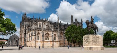 Batalha, Portekiz - Mai 27, 2024 - Batalha 'daki ortaçağ Santa Maria da Vitoria manastırının manevra cephesi, kurucu şapelin ön cephesi, Portekiz Emniyet Müdürü Nuno Alvares Pereira' nın heykeli, Portekiz